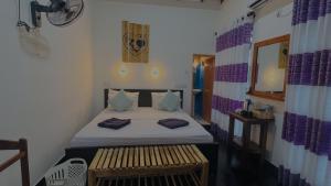 a bedroom with a bed and a bench in it at Sigiri Liya Rest in Sigiriya