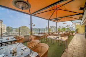 a restaurant with tables and umbrellas on a balcony at Hotel Varun in Guna