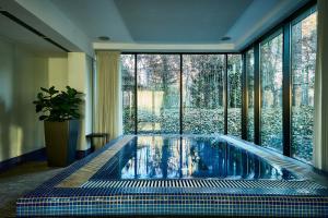 a swimming pool in a room with a large window at Platinum Palace Boutique Hotel & SPA in Wrocław