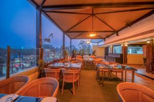 a restaurant with tables and chairs with a view at Hotel Varun in Guna