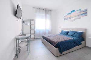 a bedroom with a bed and a table and a television at B&B a due passi dal centro in Castelsardo