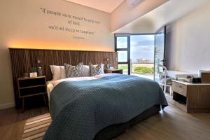 a bedroom with a bed with a sign on the wall at Oyster Box Guesthouse in Walvis Bay