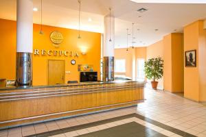 a lobby of a reederaria restaurant with yellow walls at Hotel Accademia in Przemyśl