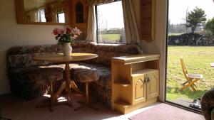 uma sala de estar com um sofá e uma mesa em Caravan by Sea em Morfa Nefyn