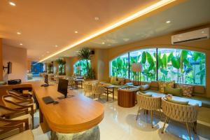 a living room with a table and a large window at TS SUITES Seminyak Bali in Legian