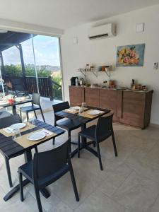 a dining room with tables and chairs and a kitchen at AmarMare Bed&Breakfast in Trappeto