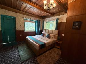a bedroom with a bed and a chandelier at havana stays in Jibhi