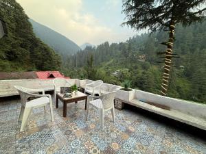 a patio with a couch and chairs and a table at havana stays in Jibhi