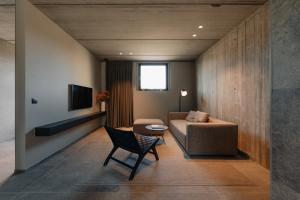 a living room with a couch and a chair at Coliving - Bord de Meuse - L'écrin Vert in Oupeye