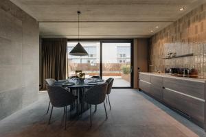 a dining room with a black table and chairs at Coliving - Bord de Meuse - L'écrin Vert in Oupeye