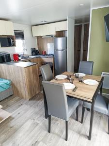 a kitchen and dining room with a table and chairs at Mobil home - La carabasse 4 Etoiles - 3 chambres in Vias