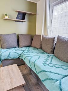 a couch with a blanket on it in a room at Mobil home - La carabasse 4 Etoiles - 3 chambres in Vias