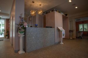 a lobby with a reception counter with flowers on it at Hotel Imperiale & SPA in Gatteo a Mare +129 photos