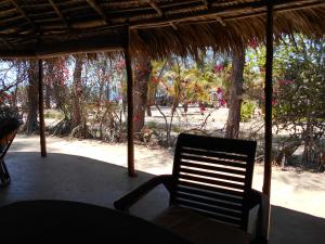 una sedia seduta in veranda con vista sulla spiaggia di Villa Miadana a Mahajanga