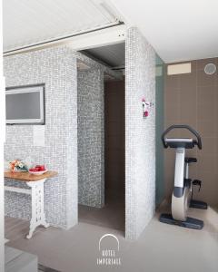a bathroom with a shower with a sink and a machine at Hotel Imperiale & SPA in Gatteo a Mare