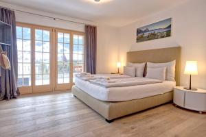 a large bedroom with a large bed with two lamps at Chalet La Gioventu - GRIWA RENT AG in Grindelwald