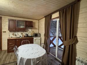 a kitchen with a table and a kitchen with a window at Лісова тиша Дворівневий Люкс in Synevyrsʼka Polyana