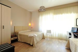 ローマにあるHoney Roomsのベッド2台とデスクが備わるホテルルームです。