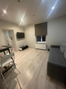 a living room with a black couch and a table at AV Apartment in Rēzekne