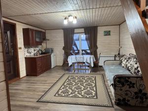 a living room with a table and a kitchen at Лісова тиша Дворівневий Люкс in Synevyrsʼka Polyana +15 photos