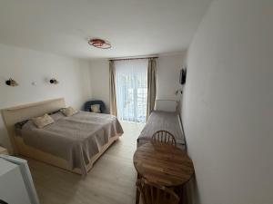 a bedroom with a bed and a table and a window at Ubytování U draka in Třeboň
