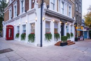 um edifício com uma porta vermelha numa rua em NOX Belsize Park em Londres