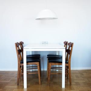 a white dining room table with four chairs at Våningen vid Havet in Simrishamn