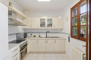 a white kitchen with white cabinets and a sink at Rustica, Centrica & Agradable in Palma de Mallorca +4 photos