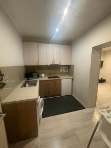 a small kitchen with white cabinets and a stove at AV Apartment in Rēzekne