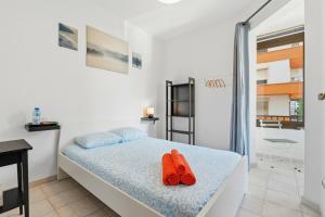 a bedroom with a bed with red flip flops on it at Rustica, Centrica & Agradable in Palma de Mallorca