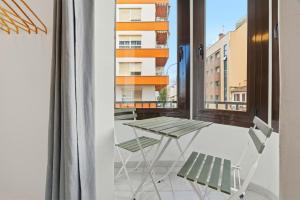 a table and chairs on a balcony with a window at Rustica, Centrica & Agradable in Palma de Mallorca