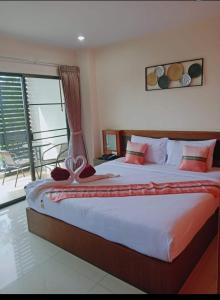 a bedroom with a large bed and a balcony at Lucky Buako Hotel Patong in Patong Beach +71 photos