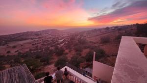 a group of people standing on a balcony watching the sunset at La Cabane Surf Lodge in Agadir +15 photos