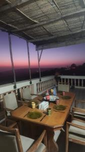 a dining room with a table and chairs and a sunset at La Cabane Surf Lodge in Agadir