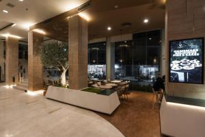 a lobby of a building with a tv and tables and chairs at Golden Crown Grand Hotel in Hat Yai
