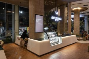 a person sitting at a counter in a store at Golden Crown Grand Hotel in Hat Yai