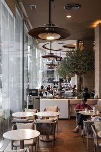 a restaurant with tables and people in a kitchen at Golden Crown Grand Hotel in Hat Yai