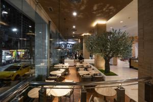 a restaurant with tables and chairs in a building at Golden Crown Grand Hotel in Hat Yai