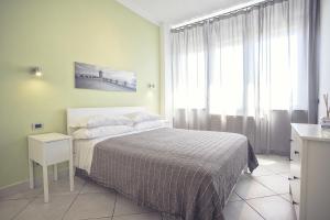 a bedroom with a bed and a large window at Excelsior in Piombino