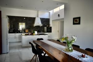 a kitchen with a wooden table with a vase of flowers on it at Secret Villa - Room Rose in Taʼ Lampuka