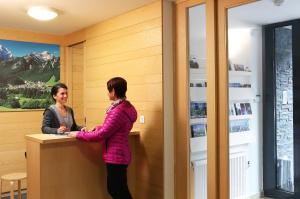 two women standing at a counter in a room at Apartments and Rooms Bernik in Kranjska Gora