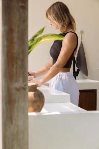 a woman standing in front of a mirror playing with a vase at Promo - Private 1BR villa for couples in Kuta Lombok