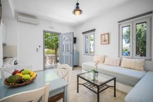 a living room with a couch and a table with a bowl of fruit at Indigo Studios in Livadi
