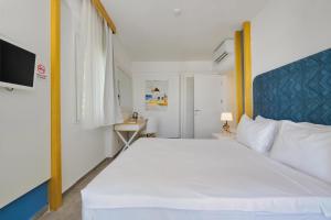 a bedroom with a large white bed with a blue headboard at Labranda TMT Bodrum in Bodrum City