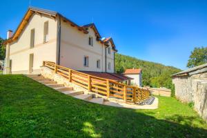 a house with a wooden staircase leading up to it at Dobra Hiša Zdravja Čičarija in Golac