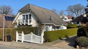 a white fence in front of a white house at Fewo Ostseetraum Laboe in Laboe