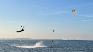 two people are kite surfing in the water at Fewo Ostseetraum Laboe in Laboe