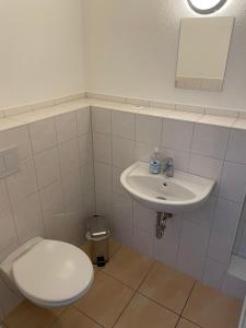 a bathroom with a toilet and a sink at Die Kantine Wittenburg Zimmervermietung und Hostel in Wittenburg