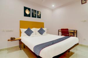 a bedroom with a large bed and a chair at Super Townhouse SR Nagar Near RCC Premier in Hyderabad