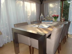 a dining room table with white chairs around it at Veluwe Park Reewold Chalet Infinity in Putten